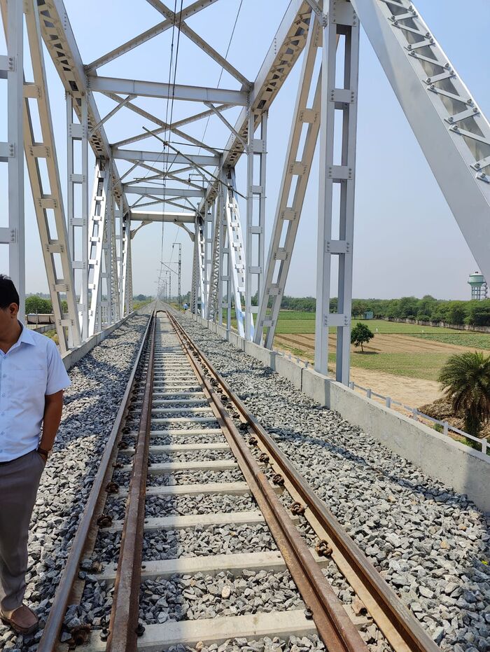 Completed steel truss railway bridge with track laid and overhead electrification in place