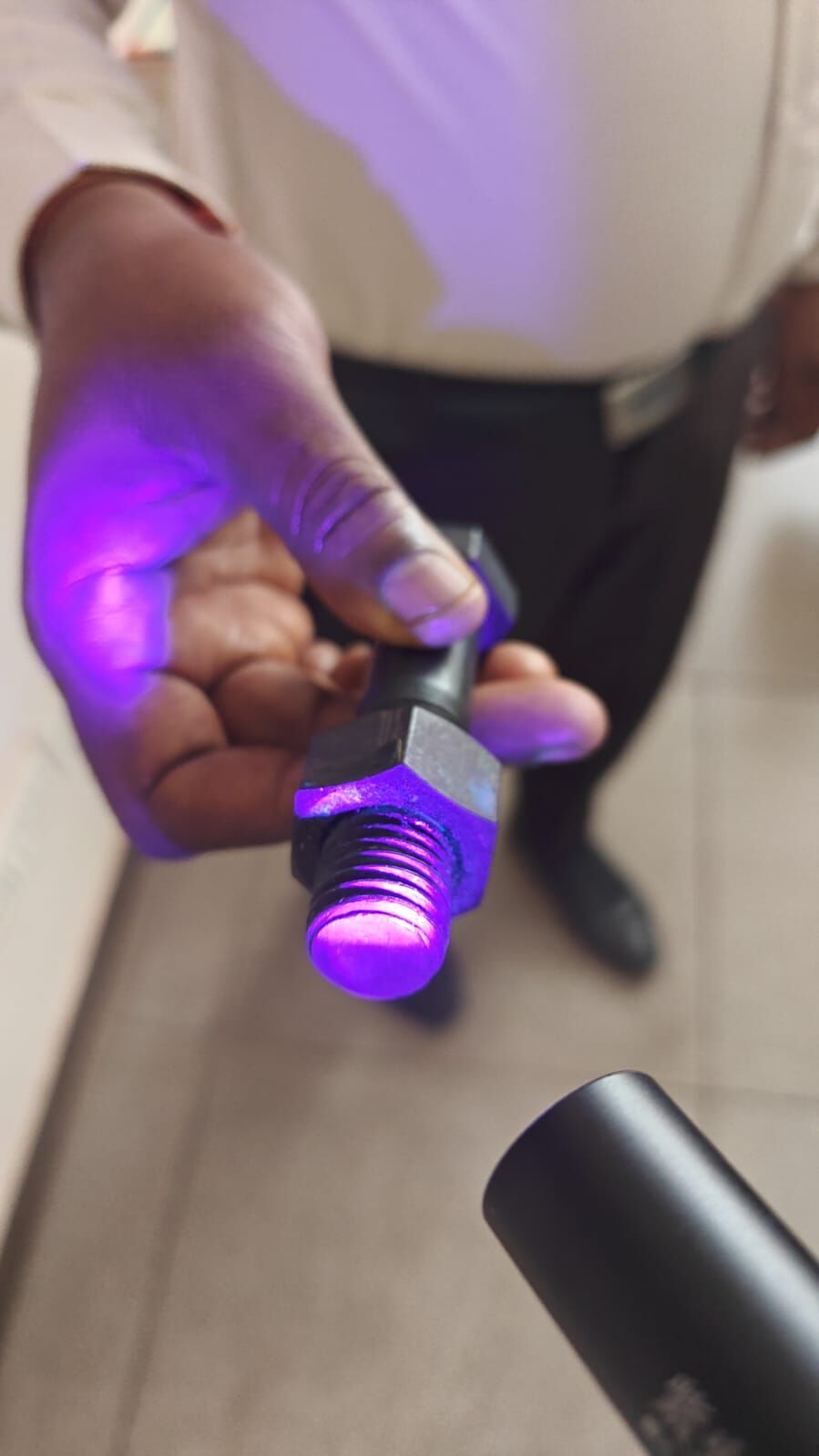 Bonding agent fluorescing violet under a UV torch on a bolt